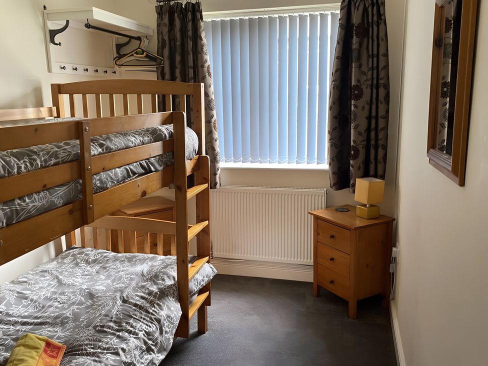 A bedroom with a bunk bed and side table at Ivy Corner