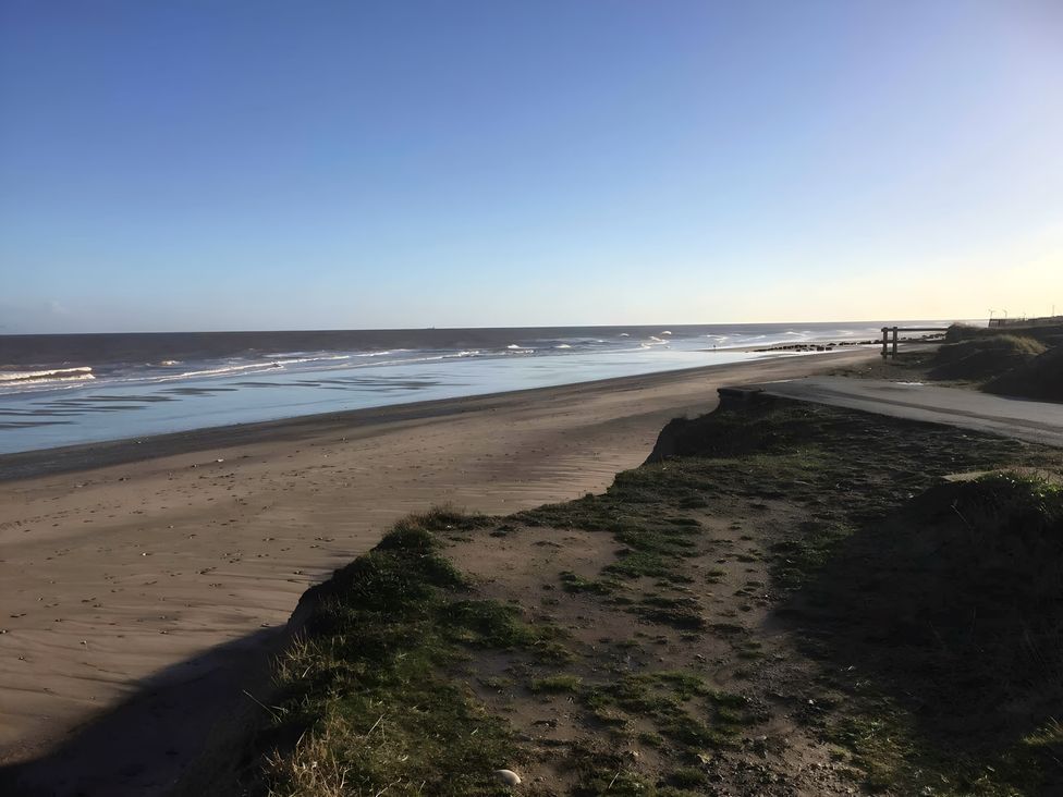 A beach with sand and ocean waves at Ivy Corner