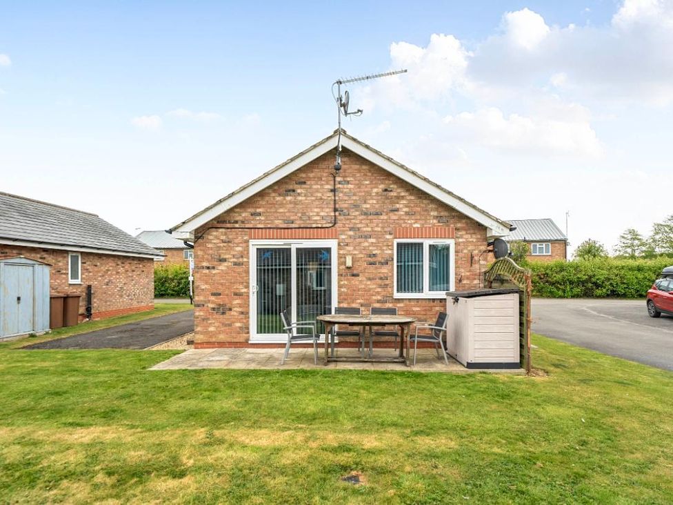 A brick house with a table and chairs at Ivy Corner in Bridlington