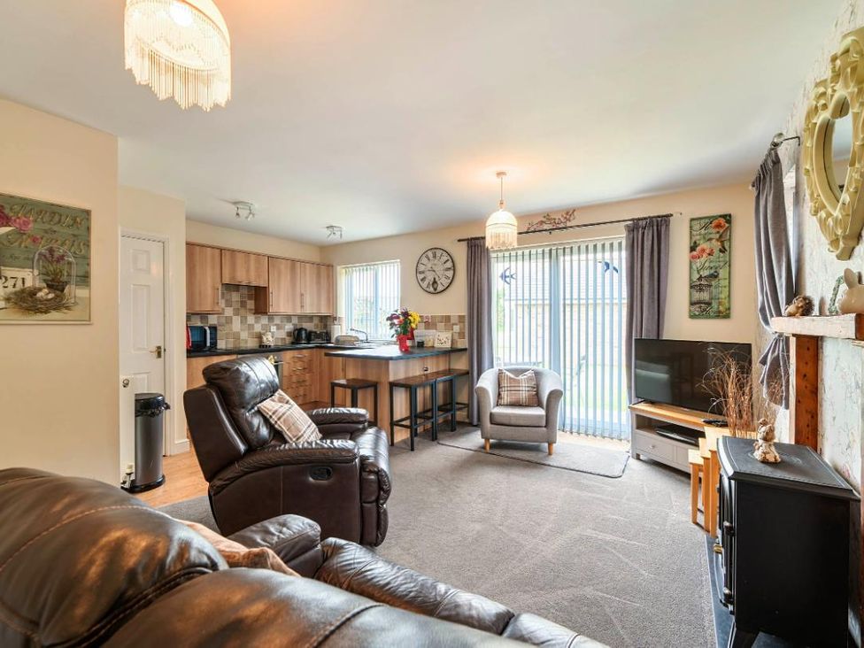 A living room with a sofa, coffee table, and television at Ivy Corner in Bridlington