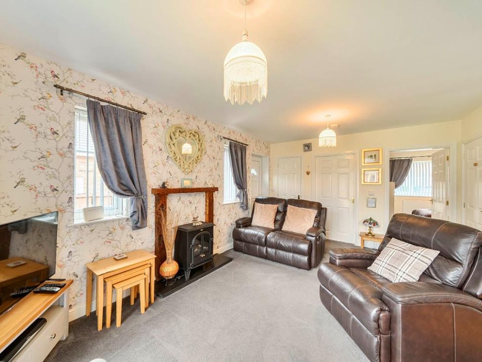 A living room with a sofa and television at Ivy Corner in Bridlington