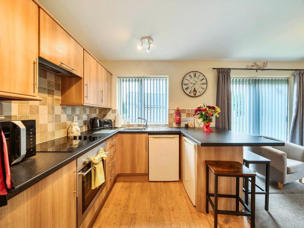 A kitchen with cabinets, appliances, and a seating area at Ivy Corner in Bridlington