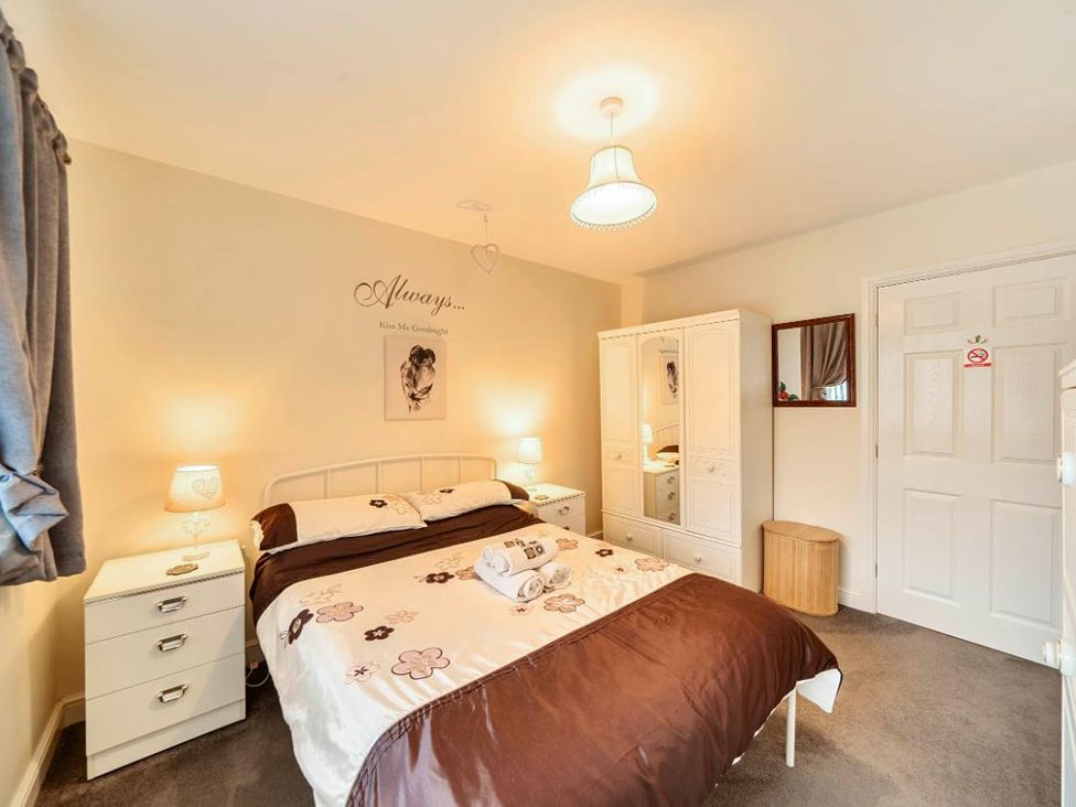 A bedroom with a bed and wardrobe at Ivy Corner in Bridlington