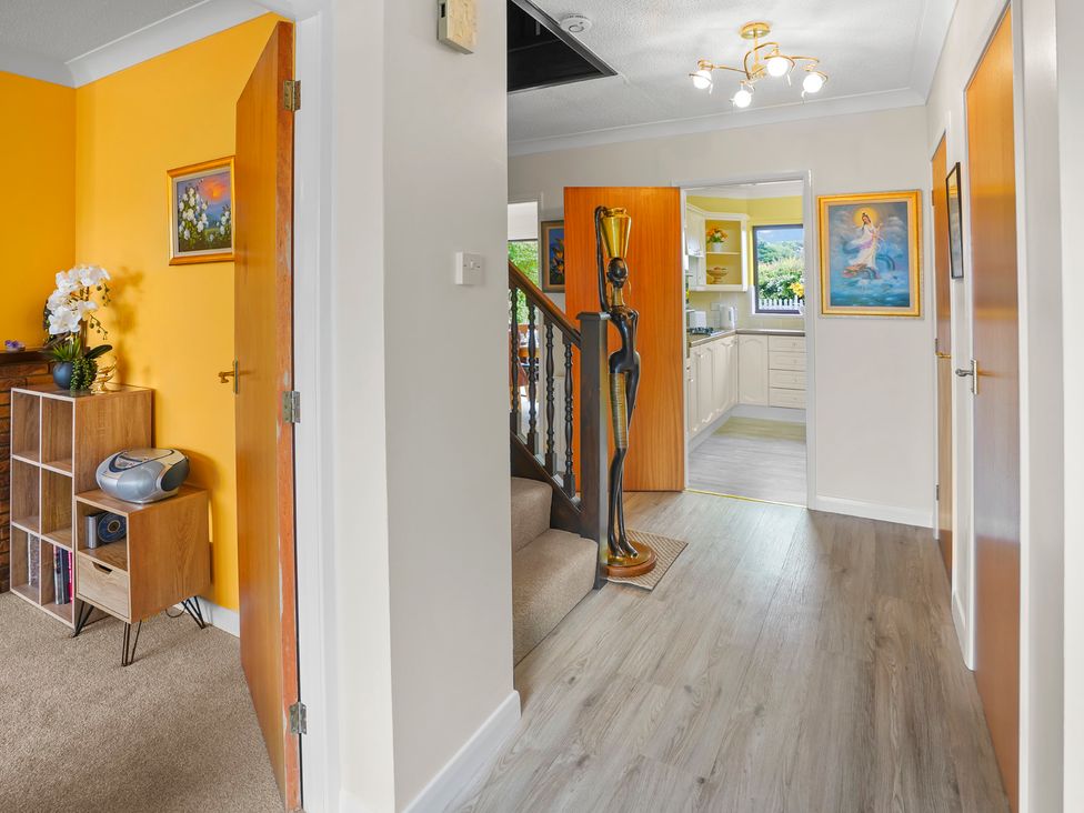A hallway with a bookshelf and staircase at The Old Barn in Manchester