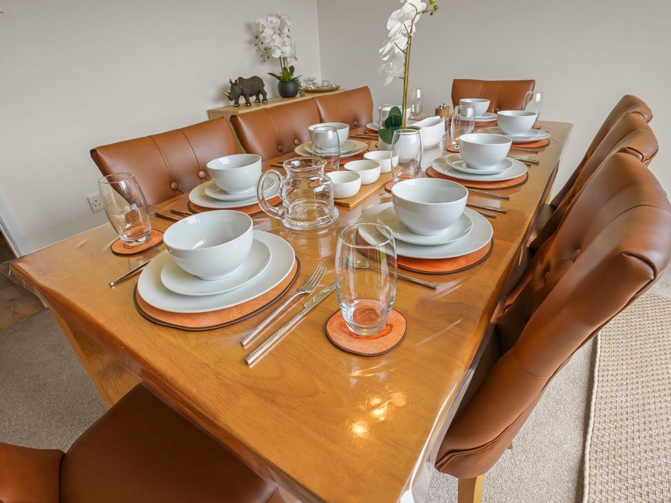 A dining table set with plates and glasses at the dining room in 