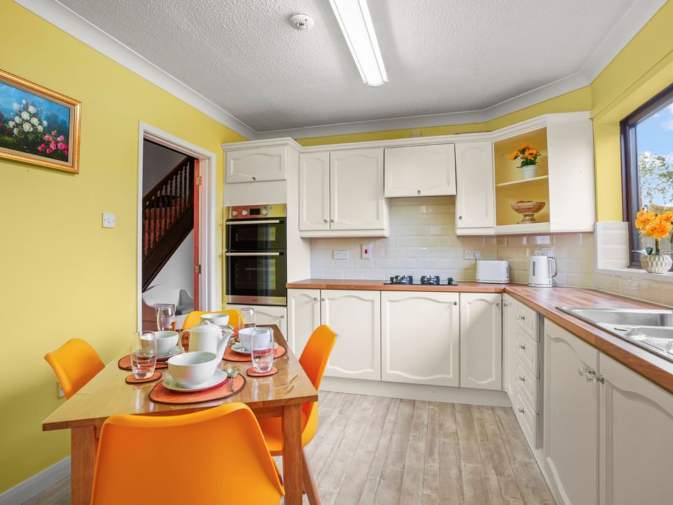 A kitchen with a dining table and orange chairs at The Old Barn in Manchester