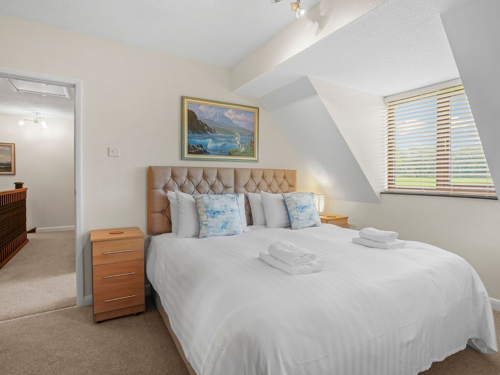 A bedroom with a bed and paintings at the property