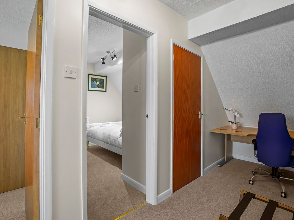 A bedroom with a desk and chair visible at a property in 