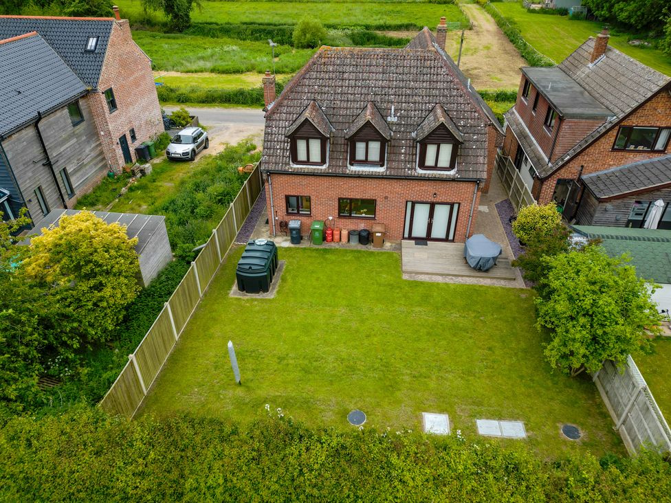 A house with a garden and wheelie bins at a property in an outdoor area