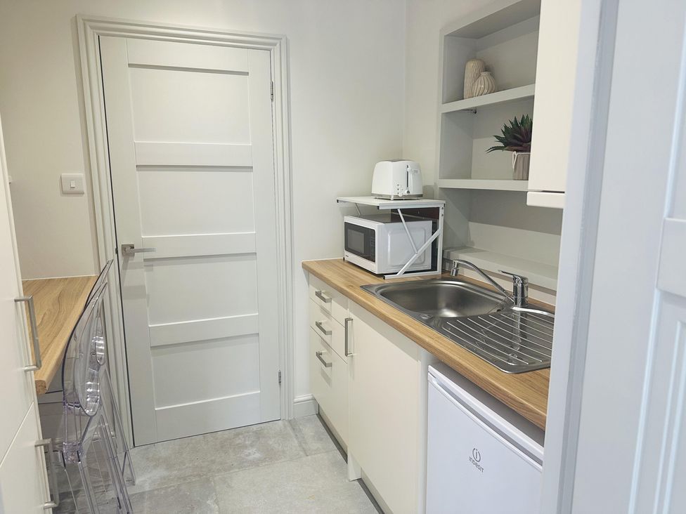 A kitchen with a sink, microwave, and toaster at Quay house studio