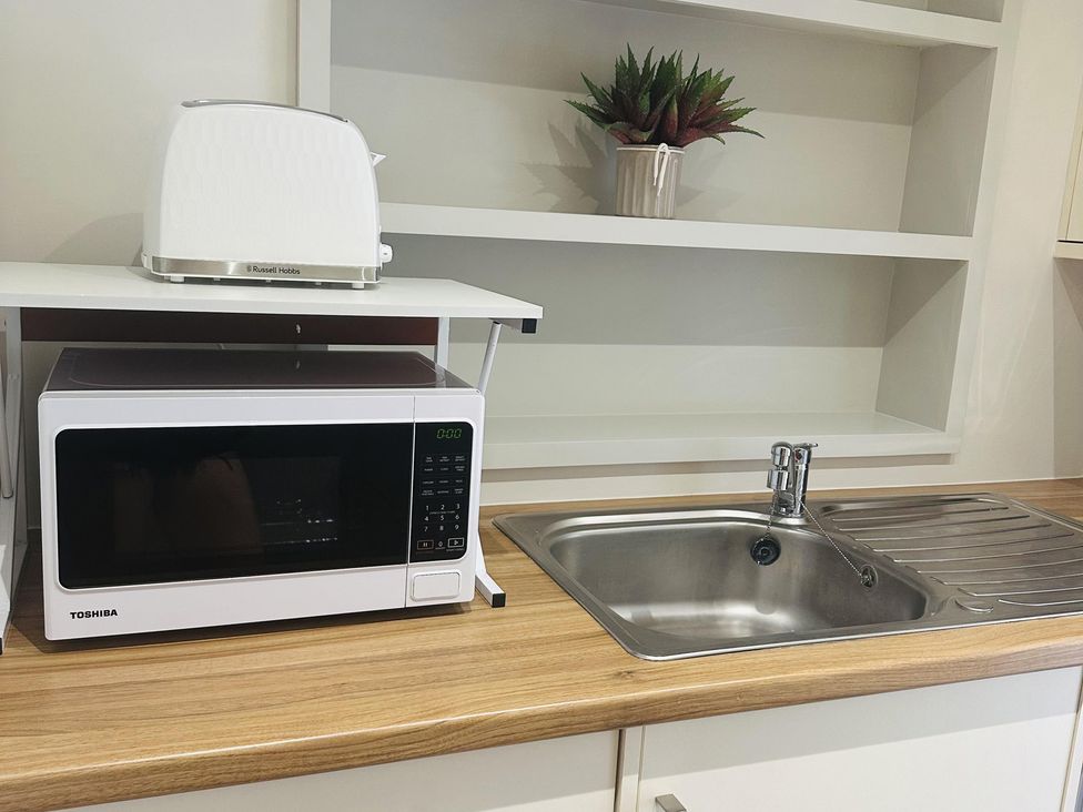 A kitchen with a microwave, toaster, and sink at Quay house studio