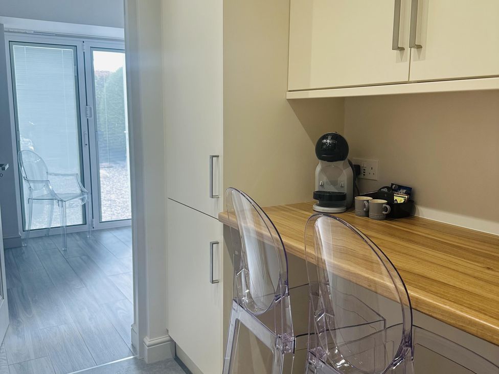 A kitchen with a coffee maker and bar stools at Quay house studio 