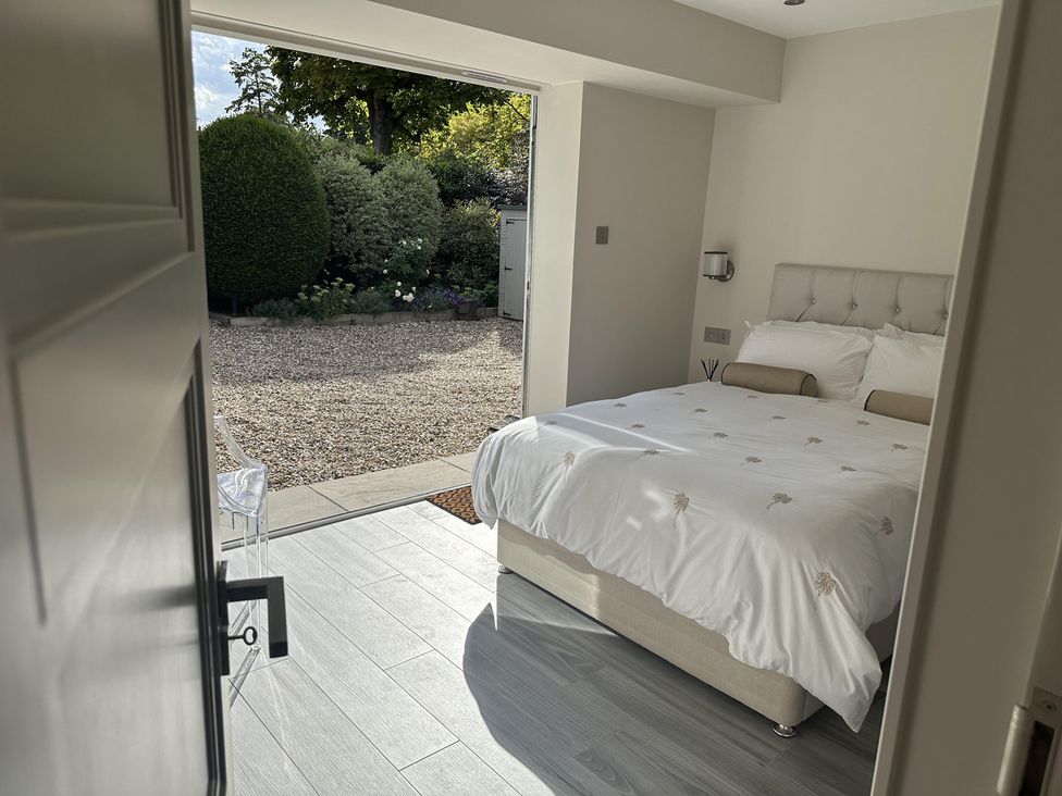 A bedroom with a bed and door leading to a garden at Quay house studio 