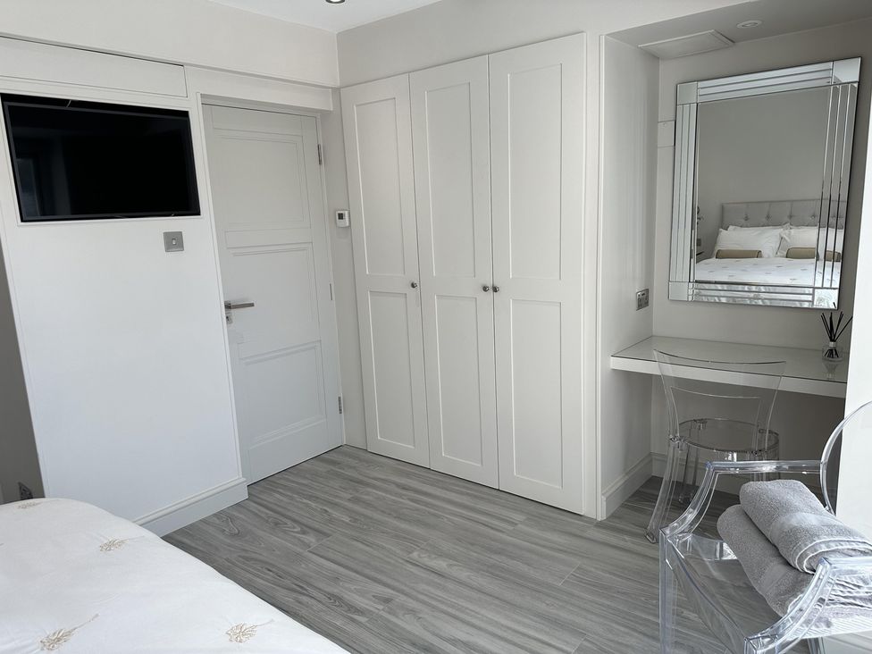 A bedroom with a wardrobe and a mirror at Quay house studio