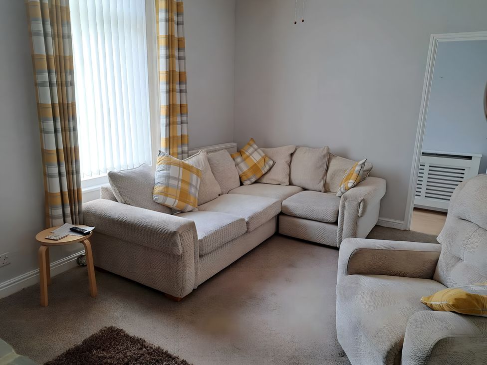 A living room with a sofa and chair at Fisherman's Cottage