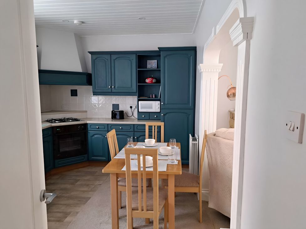 A kitchen with a dining table and chairs at Fisherman's Cottage in 