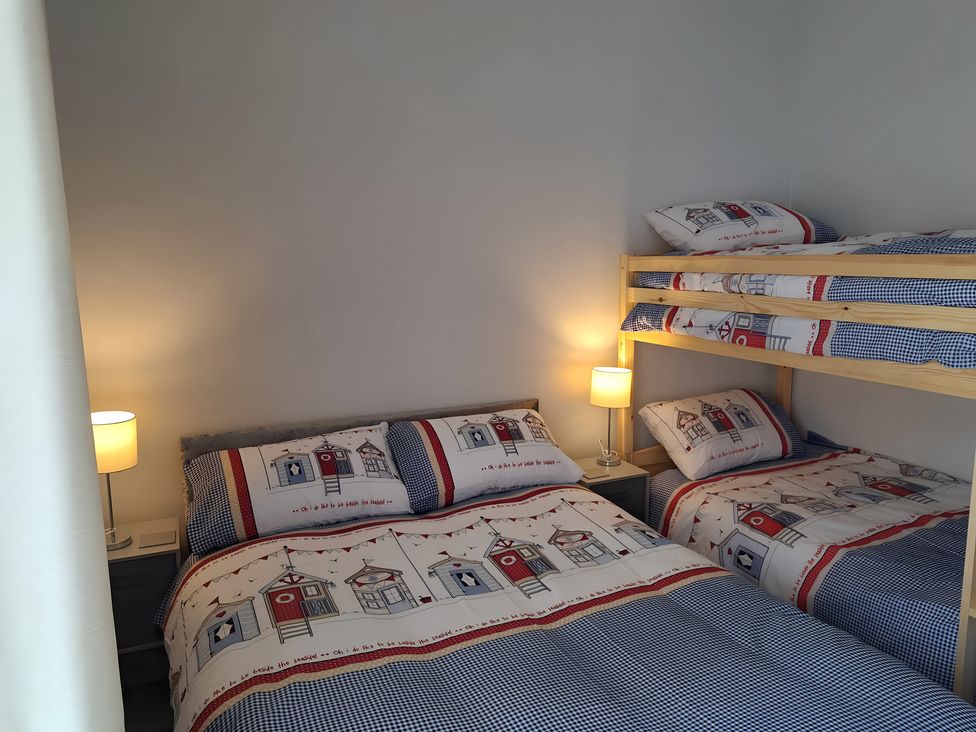 A bedroom with bunk bed and double bed at Fisherman's Cottage