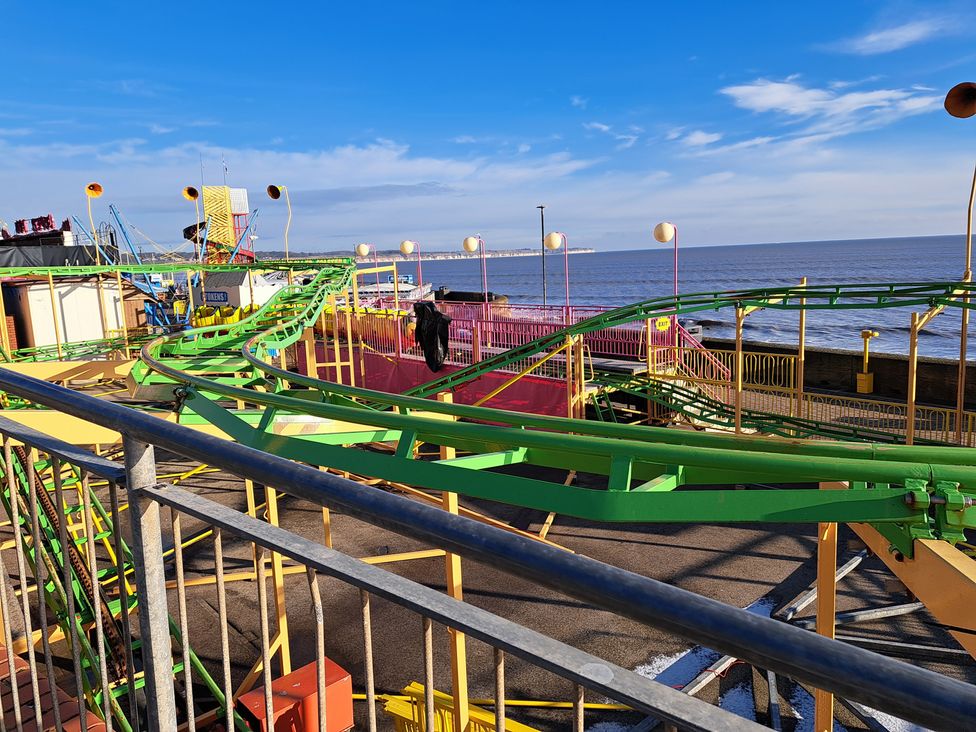 A roller coaster with green tracks at an amusement park by the sea at Fisherman's Cottage in 