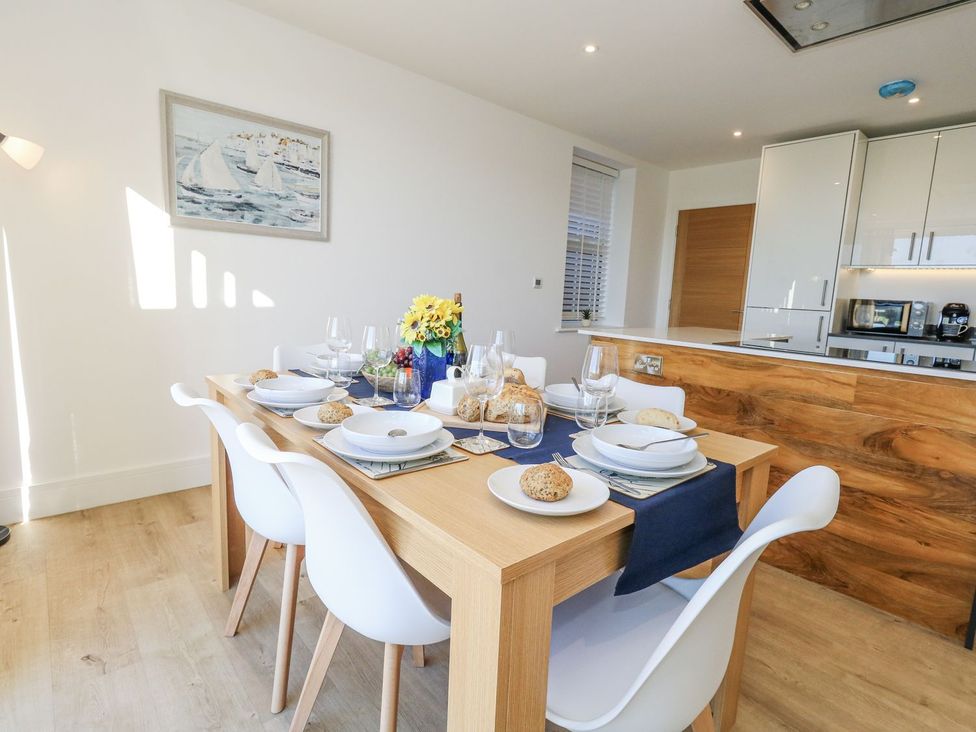 A dining room with a table set for a meal at Sea Fern House - 36 Poole