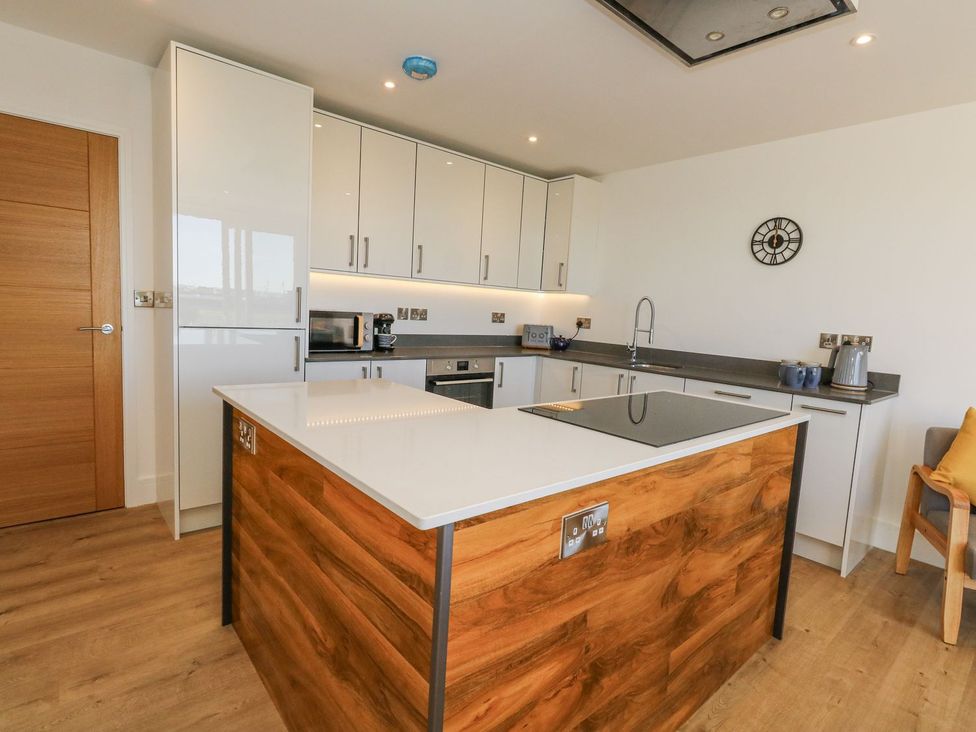 A kitchen with cabinets and an island at Sea Fern House - 36 Poole