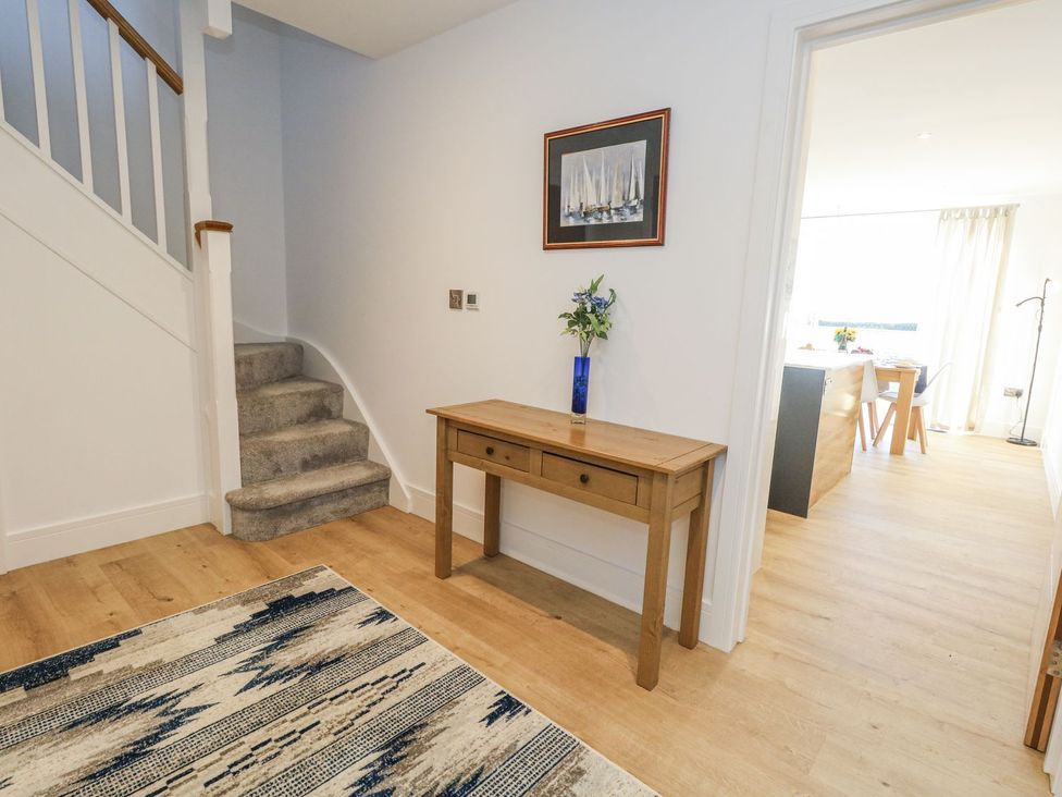 A hallway with a table and stairs at Sea Fern House - 36 in Poole