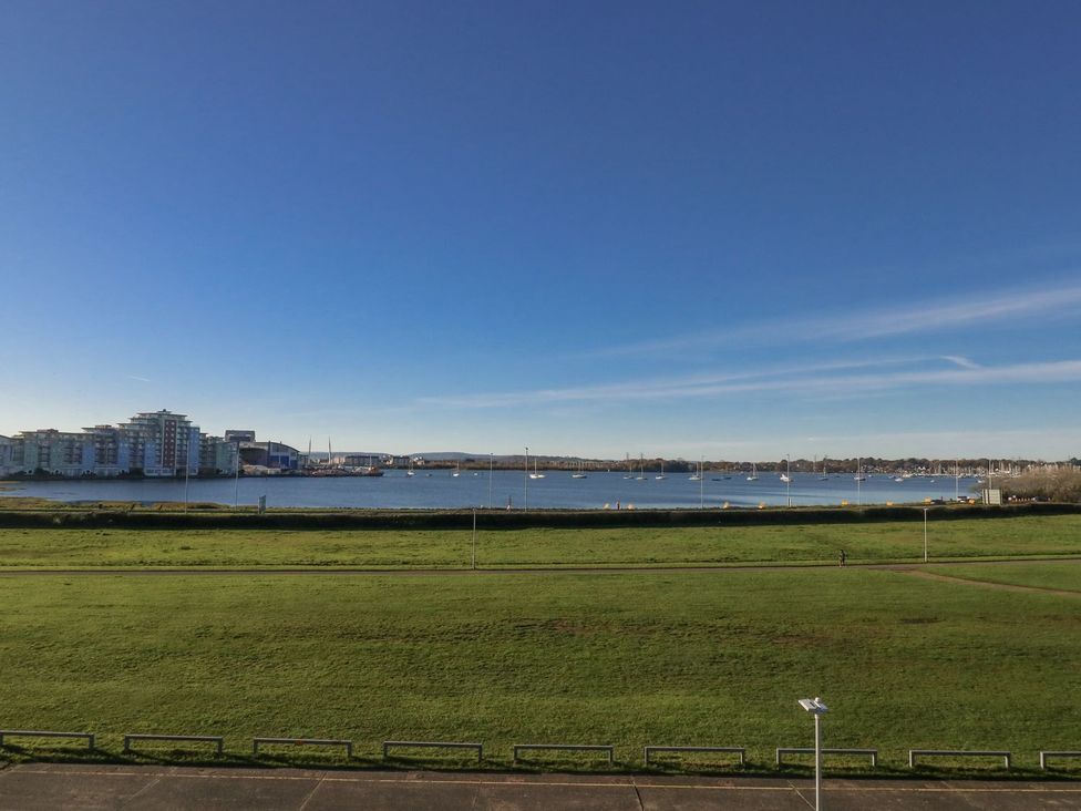 A view of water with boats and grass at Sea Fern House - 36 Poole