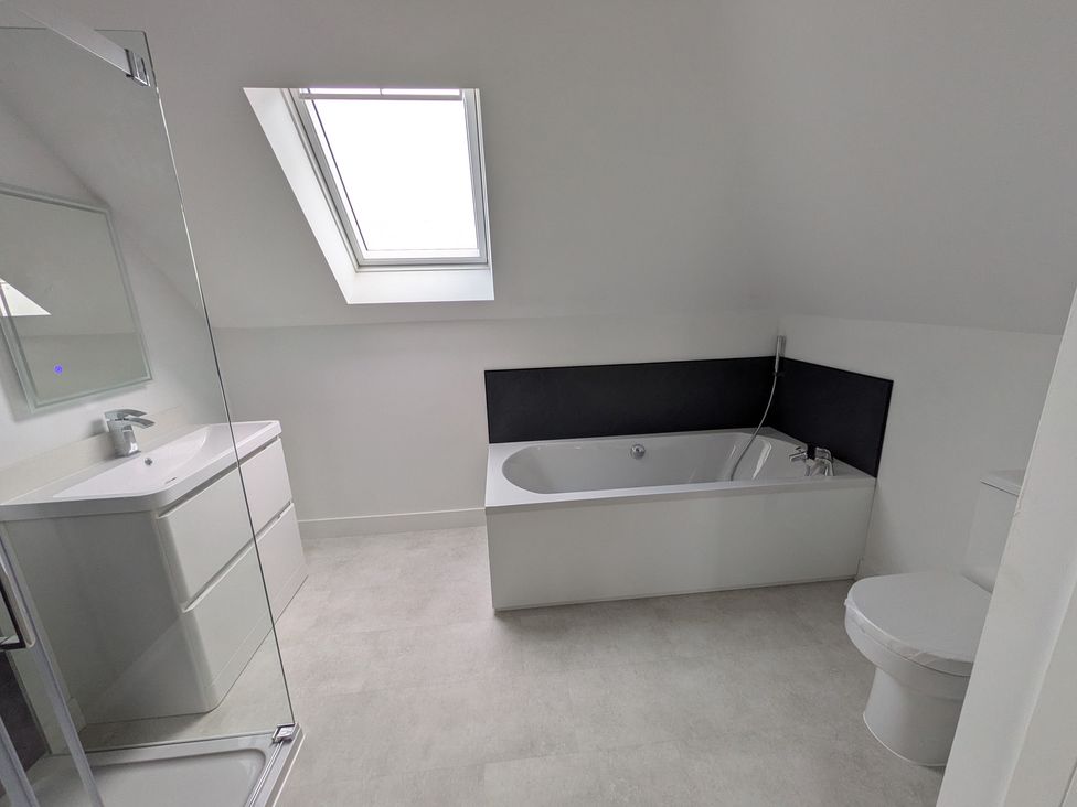 A bathroom with a bathtub and a sink at Sea Fern House - 36 in Poole