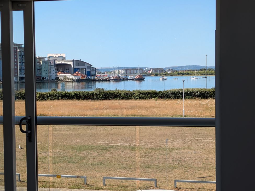 A view of water and boats from a window at Sea Fern House - 36 in Poole