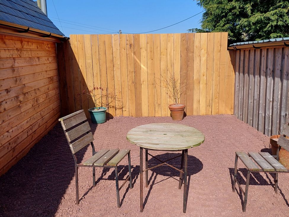 An outdoor seating area with a wooden table and chairs at location