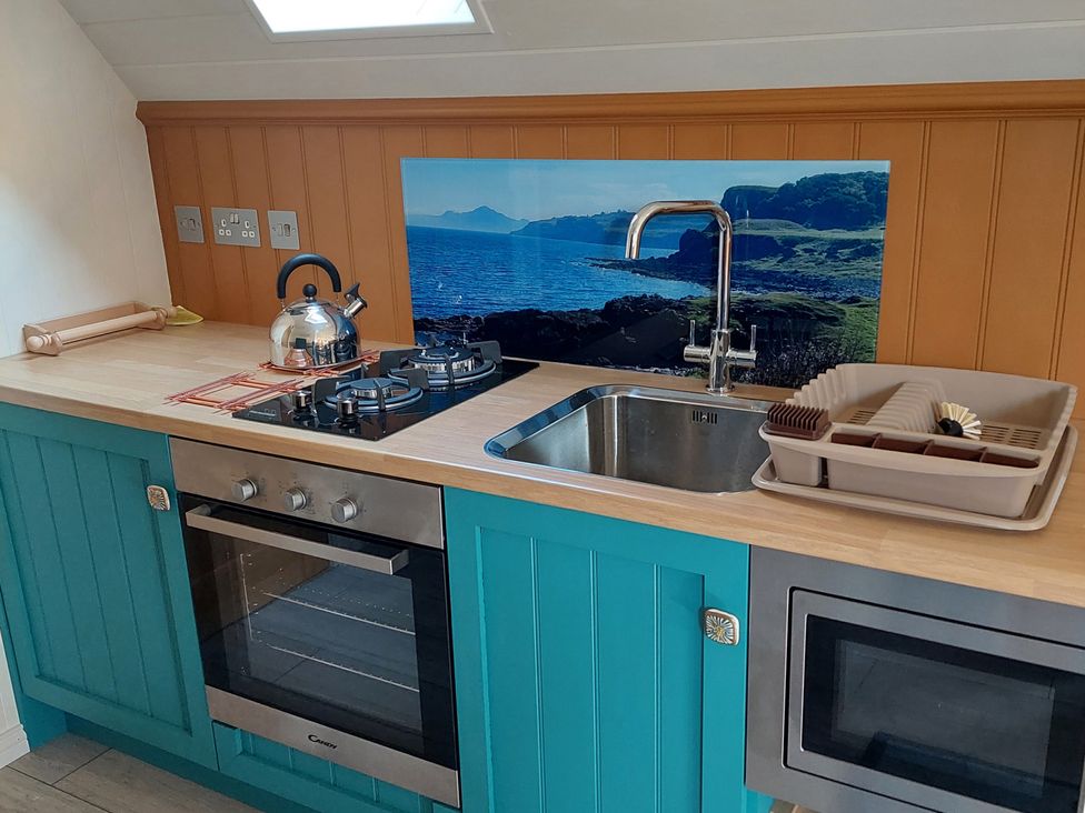 A kitchen with a kettle, sink, stovetop, oven, and microwave at The Old Barn in Manchester