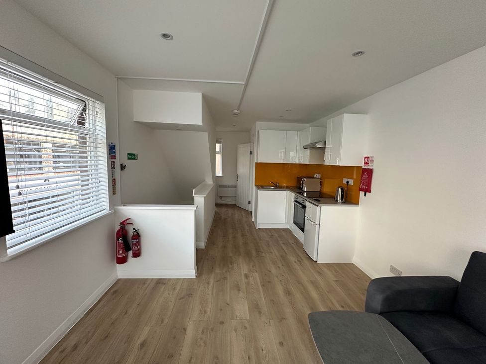 A kitchen with a stove, oven, and fire safety equipment at Red Rose Apartment