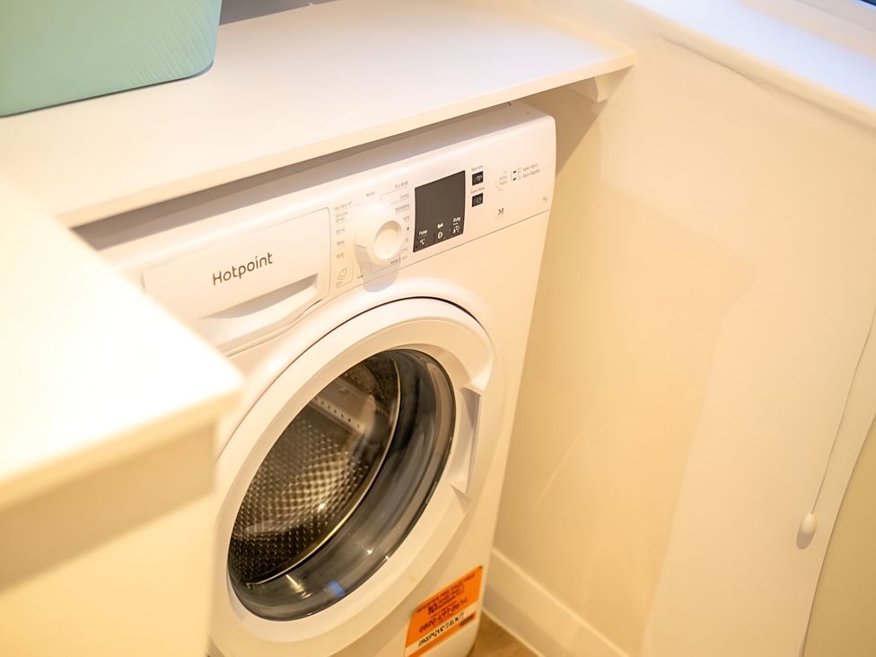 A washing machine next to a countertop at Red Rose Apartment