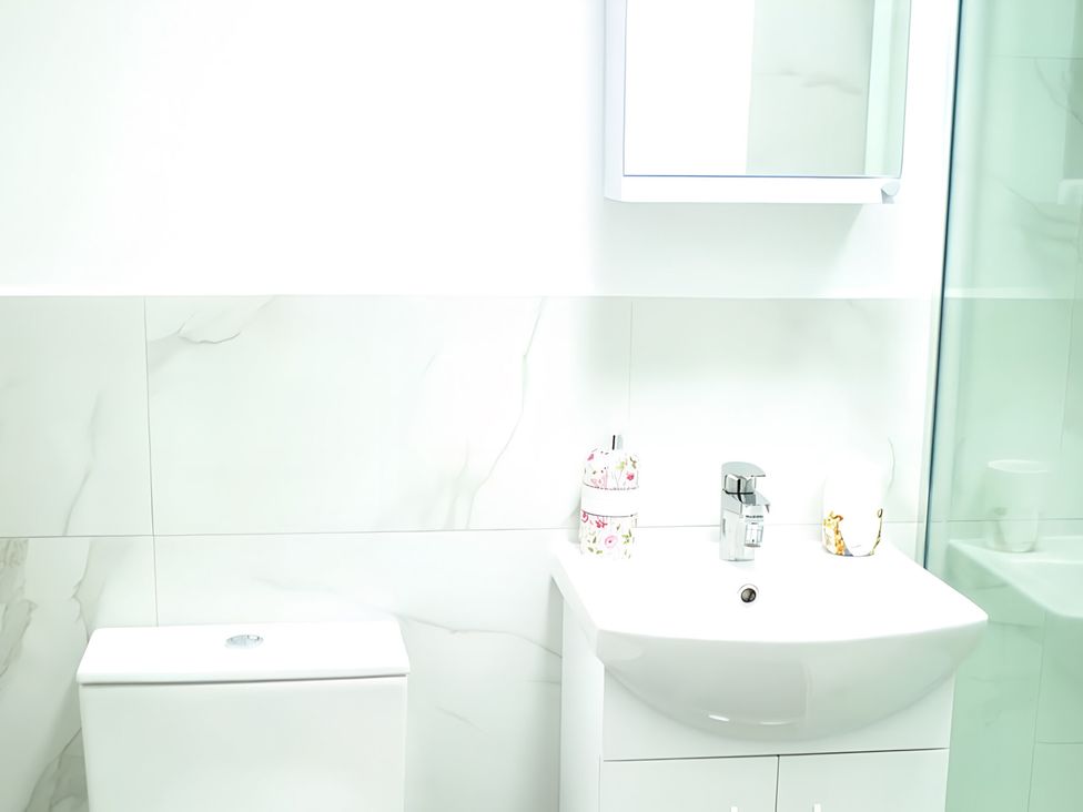 A bathroom with a sink and toilet at Red Rose Apartment