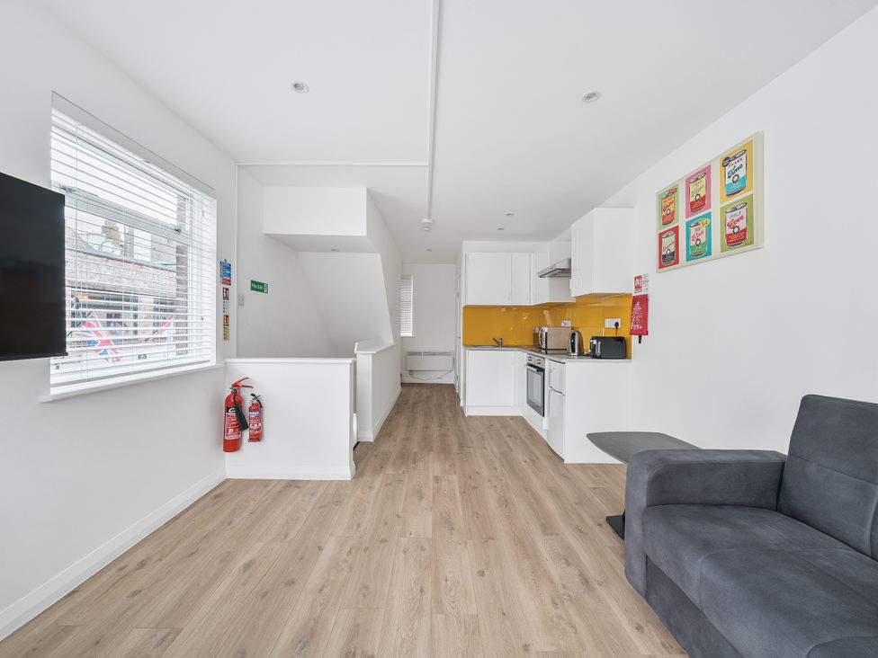 A kitchen area with a sofa and appliances at Red Rose Apartment in Weymouth