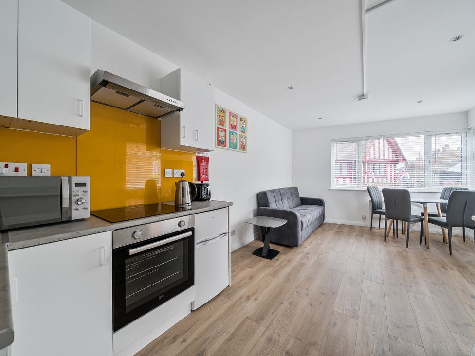 A kitchen with appliances and seating at Red Rose Apartment in Weymouth