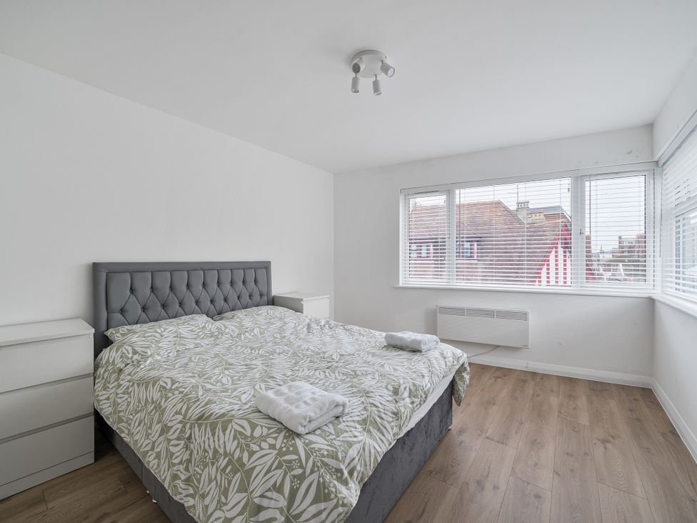 A bedroom with a bed and bedside tables at Red Rose Apartment in Weymouth