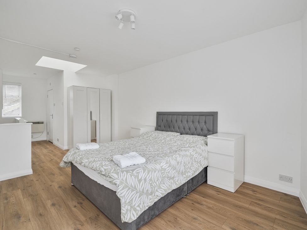 A bedroom with a bed and wardrobe at Red Rose Apartment in Weymouth