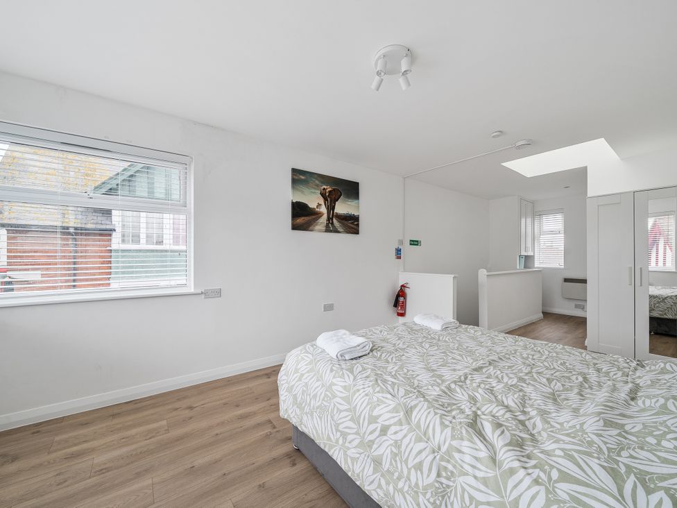 A bedroom with a bed and wardrobe at Red Rose Apartment in Weymouth