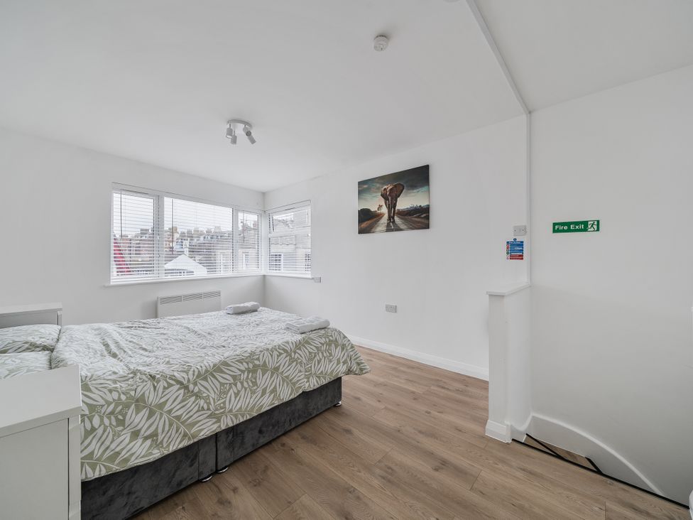 A bedroom with a bed and artwork at Red Rose Apartment in Weymouth