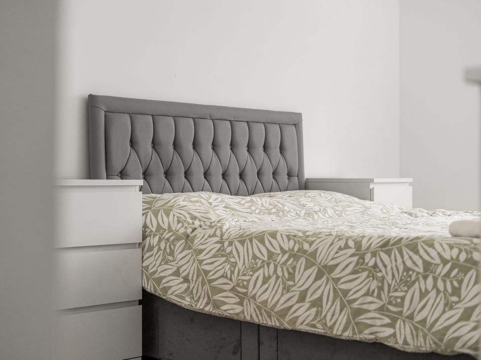 A bedroom with a bed and nightstands at Red Rose Apartment in Weymouth