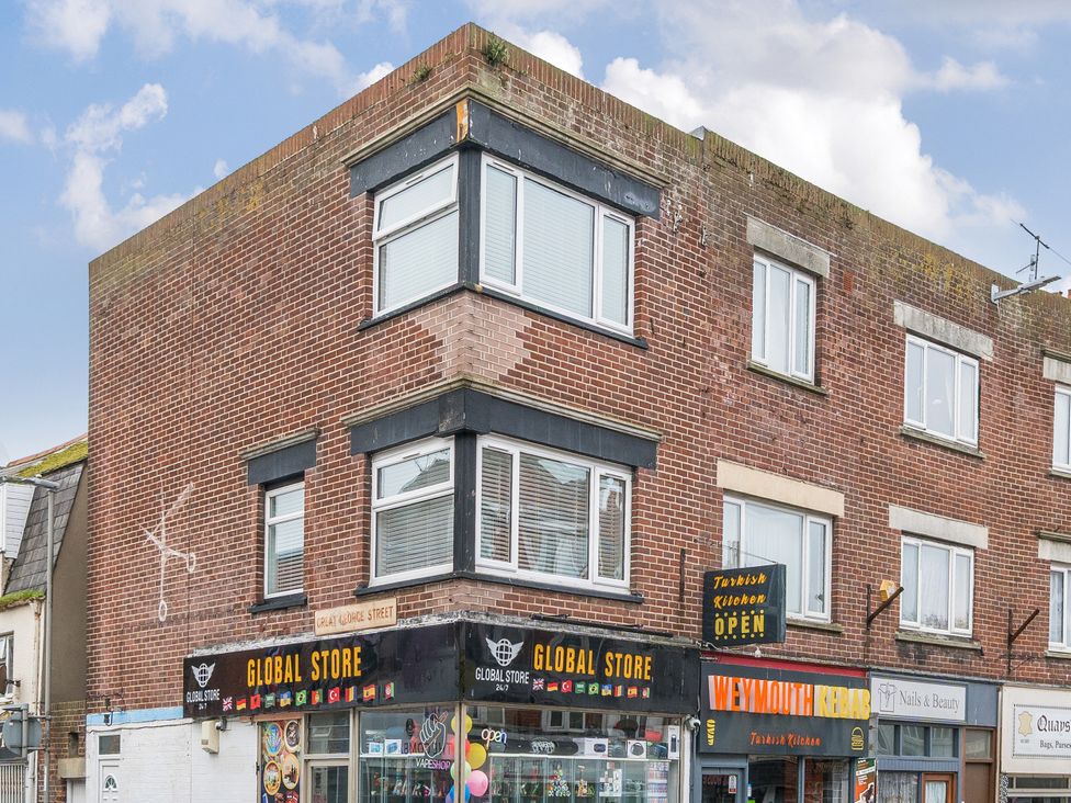 A building with a store and windows at Red Rose Apartment Weymouth