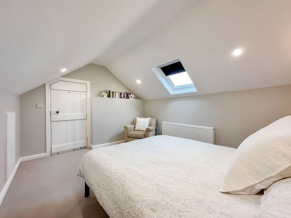 A bedroom with a bed and chair at Victorian Beach House