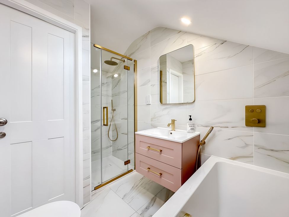 A bathroom with shower and sink at Victorian Beach House 