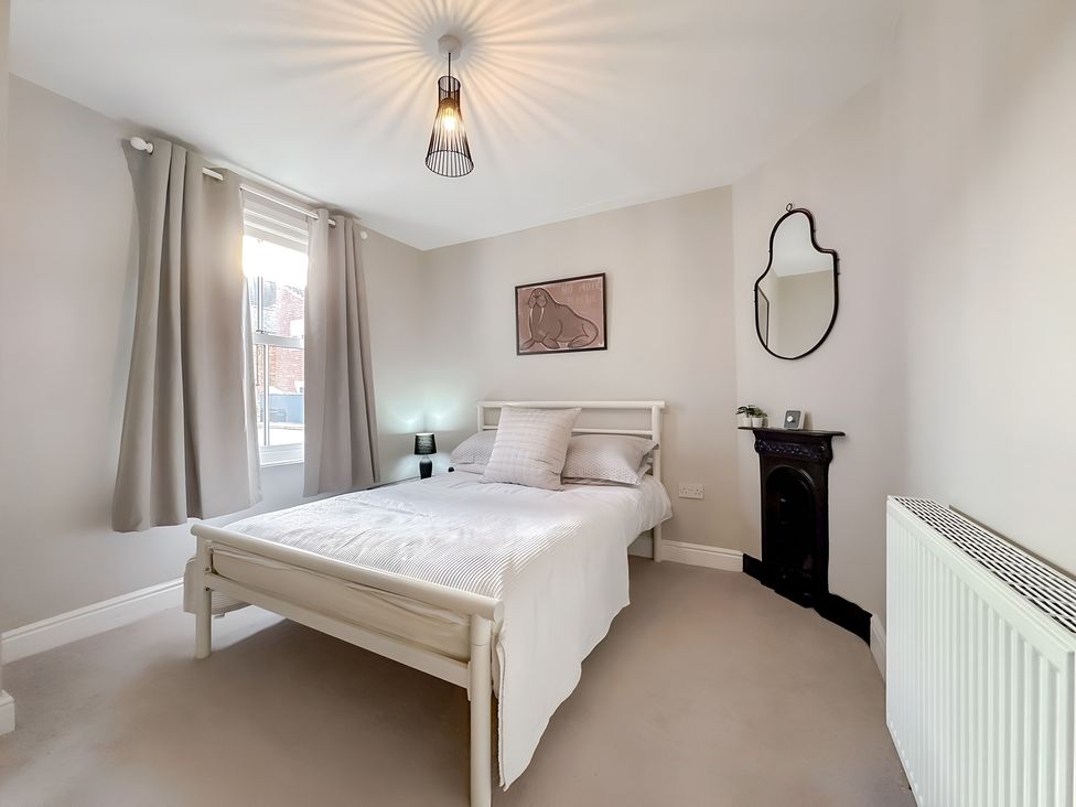A bedroom with a bed and window at Victorian Beach House