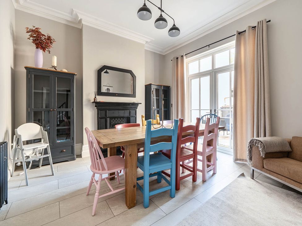 A dining room with a table and colorful chairs at Victorian Beach House in Saltburn-By-The-Sea