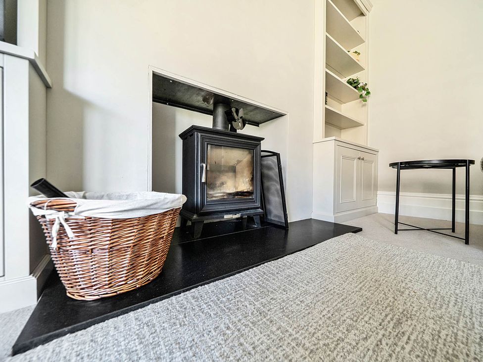 A living room with a fireplace and a storage cabinet at Victorian Beach House in Saltburn-By-The-Sea