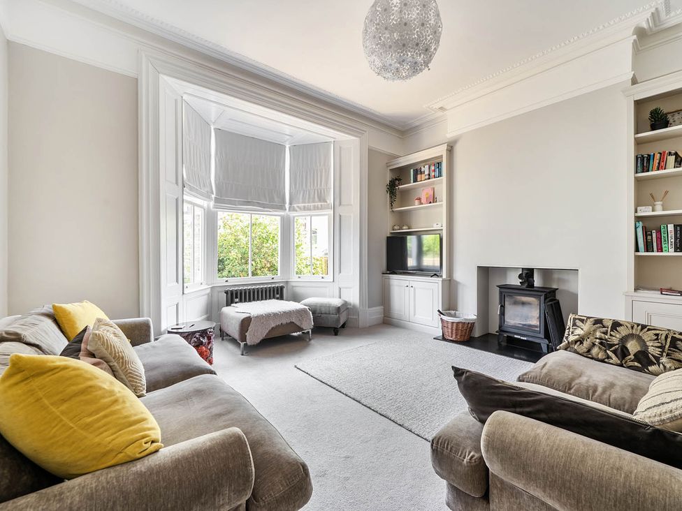 A living room with a sofa and television at Victorian Beach House in Saltburn-By-The-Sea