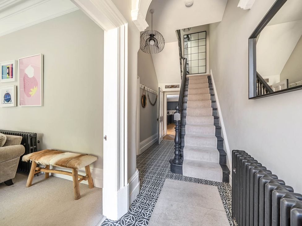 A hallway with a staircase and pictures at Victorian Beach House in Saltburn-By-The-Sea