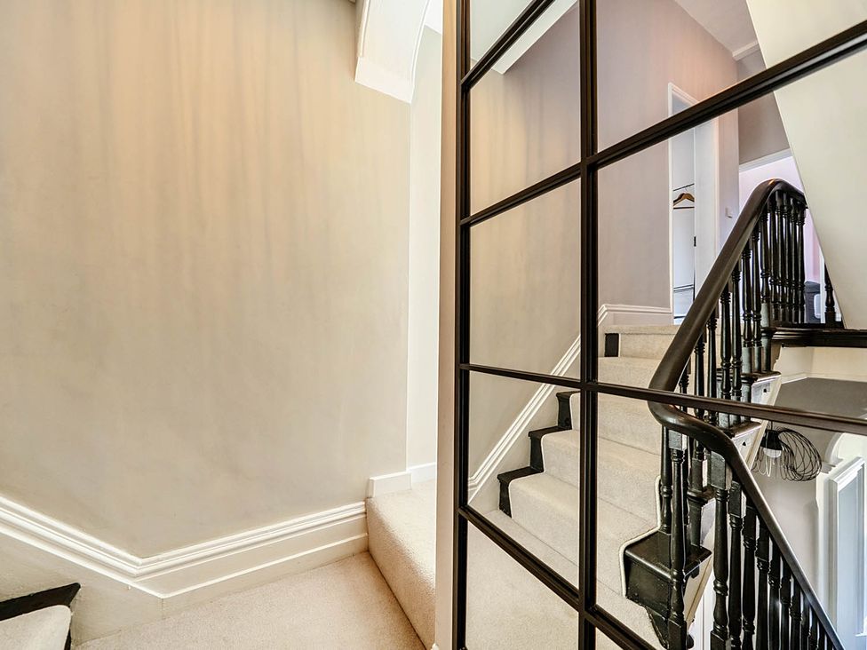 A staircase with a mirror in a hallway at Victorian Beach House Saltburn-By-The-Sea