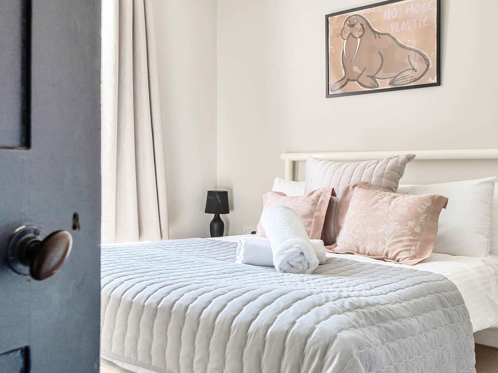 A bedroom with a bed and decorative pillows at Victorian Beach House in Saltburn-By-The-Sea